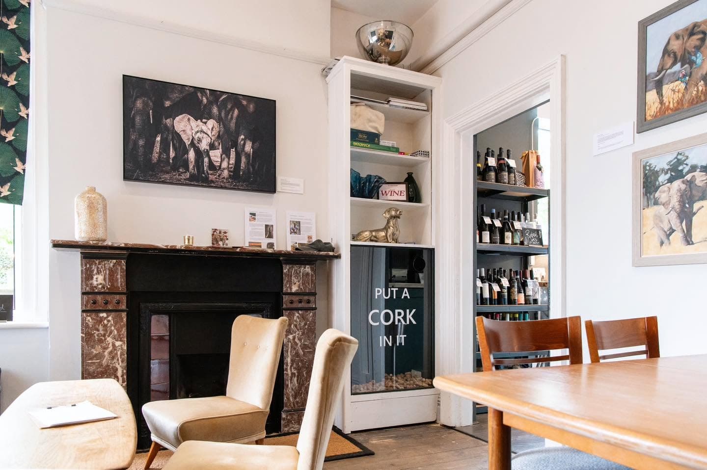 The Gallery Lounge at Blended with armchairs by the fireplace and original African wildlife artwork on the walls