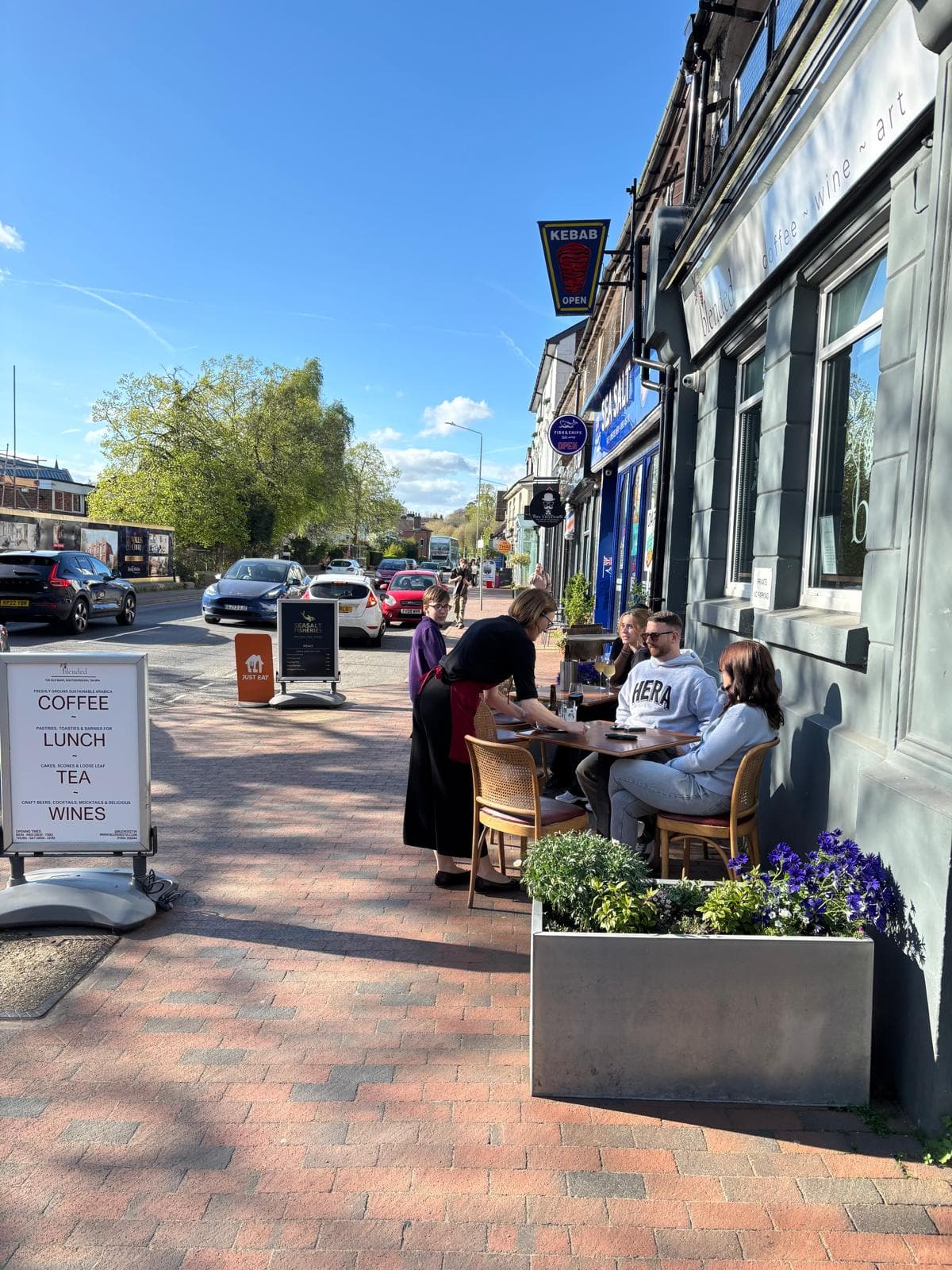 Customers enjoying drinks at the pavement tables outside Blended on a sunny day